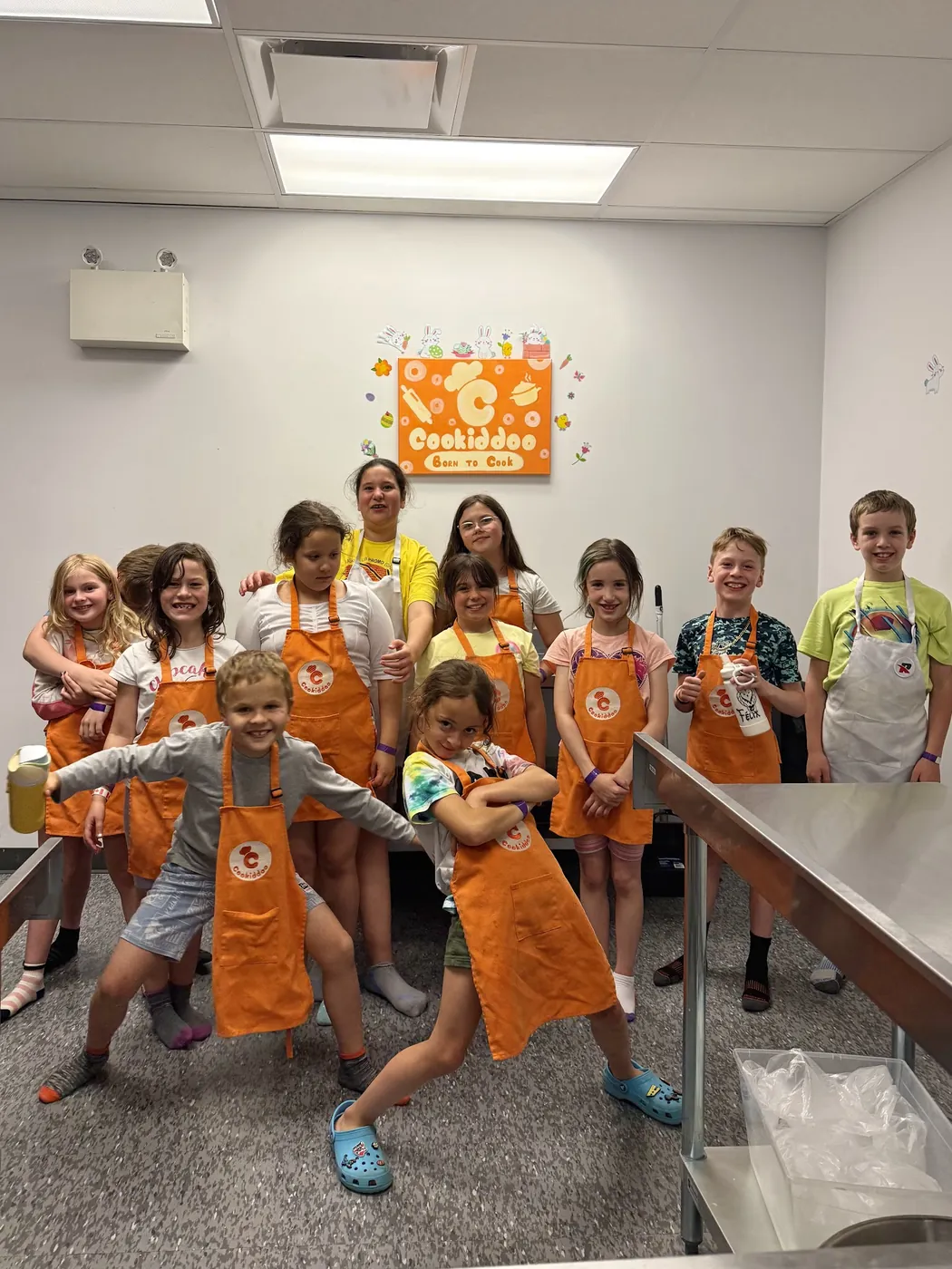A group of kids in orange Cookiddoo aprons after a cooking class in Kanata, Ottawa