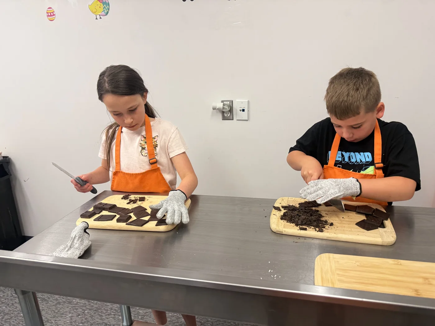 Kids in orange aprons cooking hands-on at a Cookiddoo class in Kanata, Ottawa