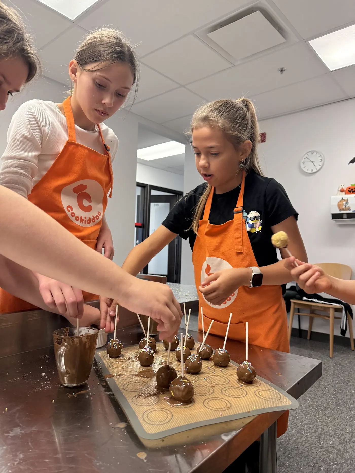 Children making treats together at one table during a Cookiddoo kids birthday party in Ottawa