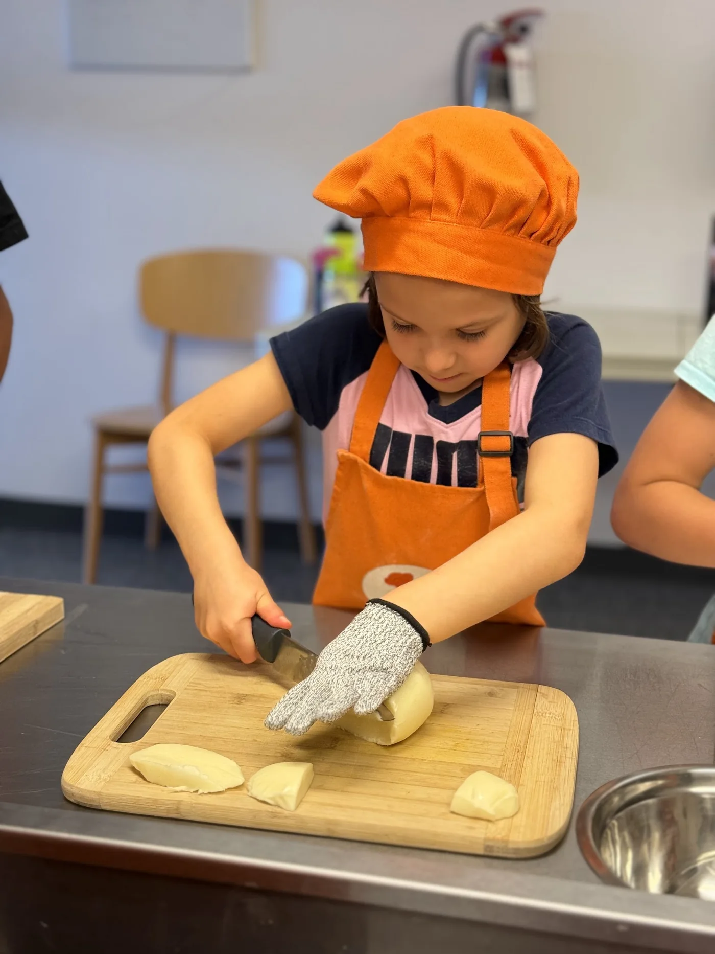 Child practising knife skills safely at a Cookiddoo cooking class in Kanata, Ottawa